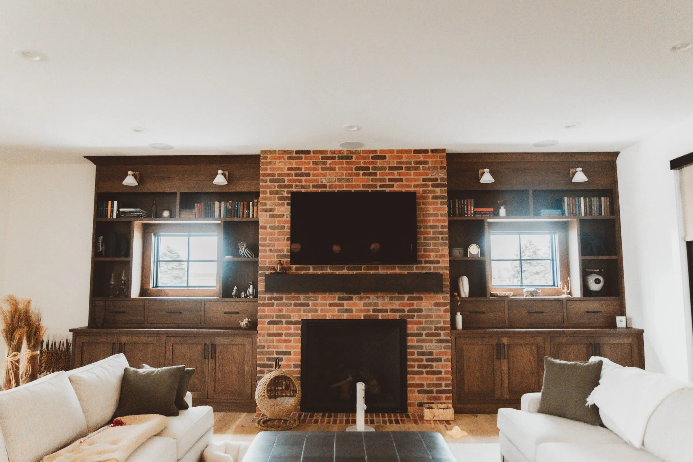 Family room with a brick fireplace and built-in shelves