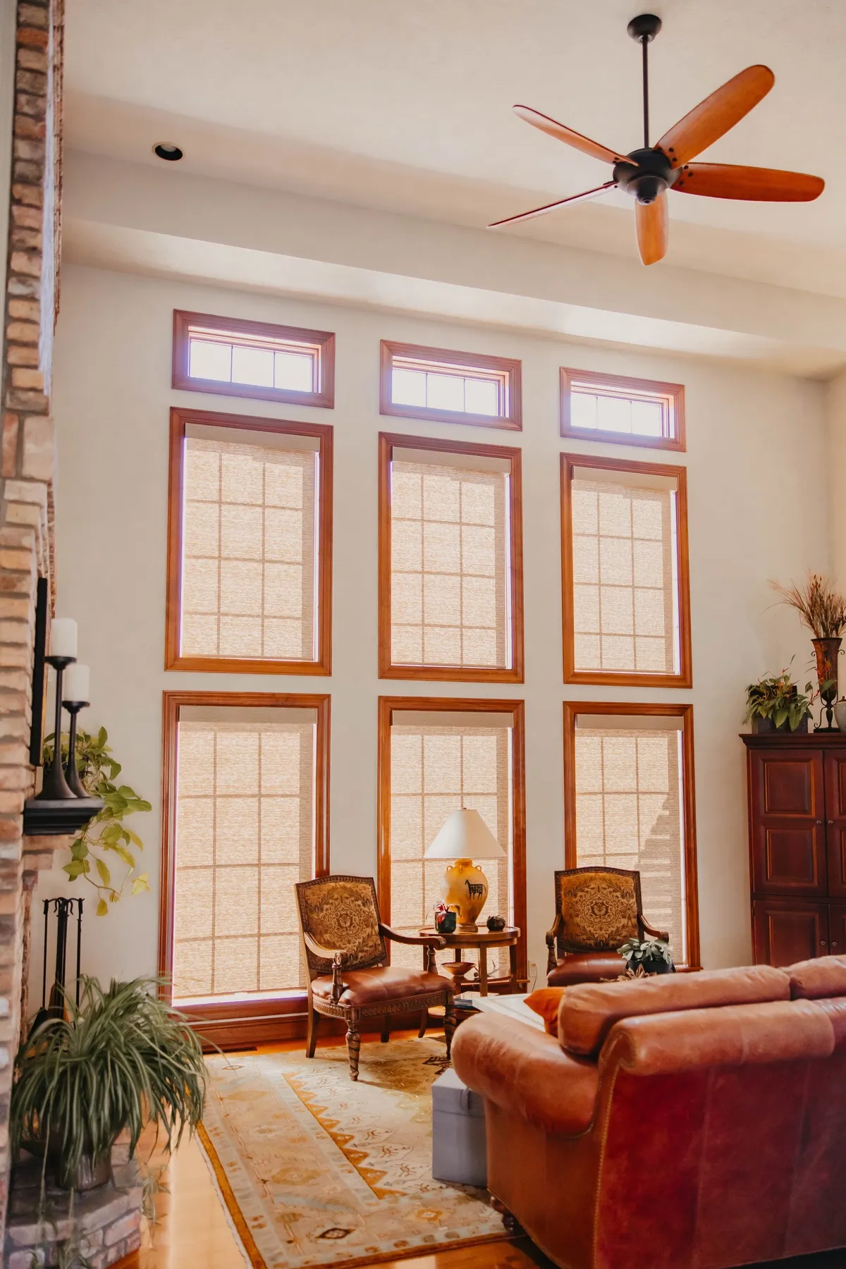 Living room with a two-story wall of windows dressed in screen shades