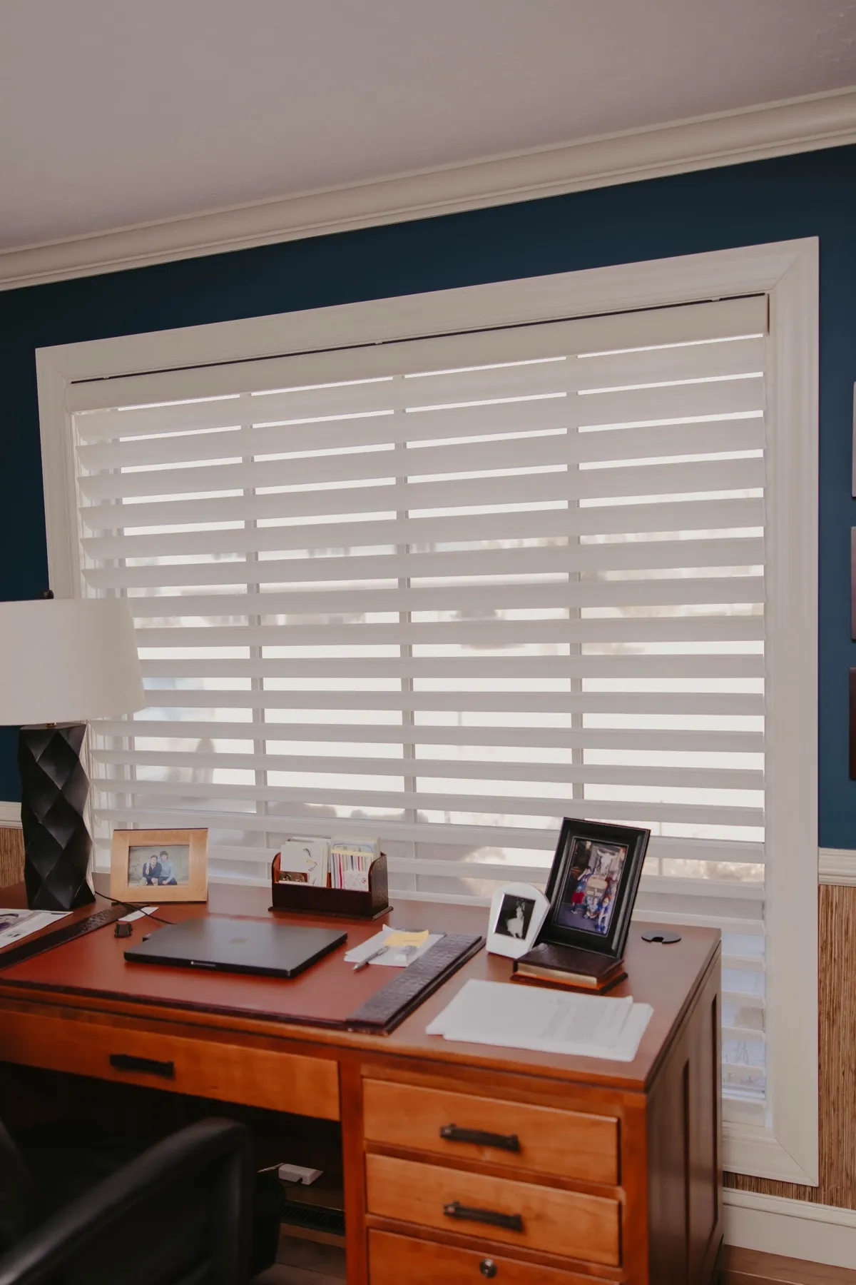 Home office window with a Pirouette® shade above a wood desk