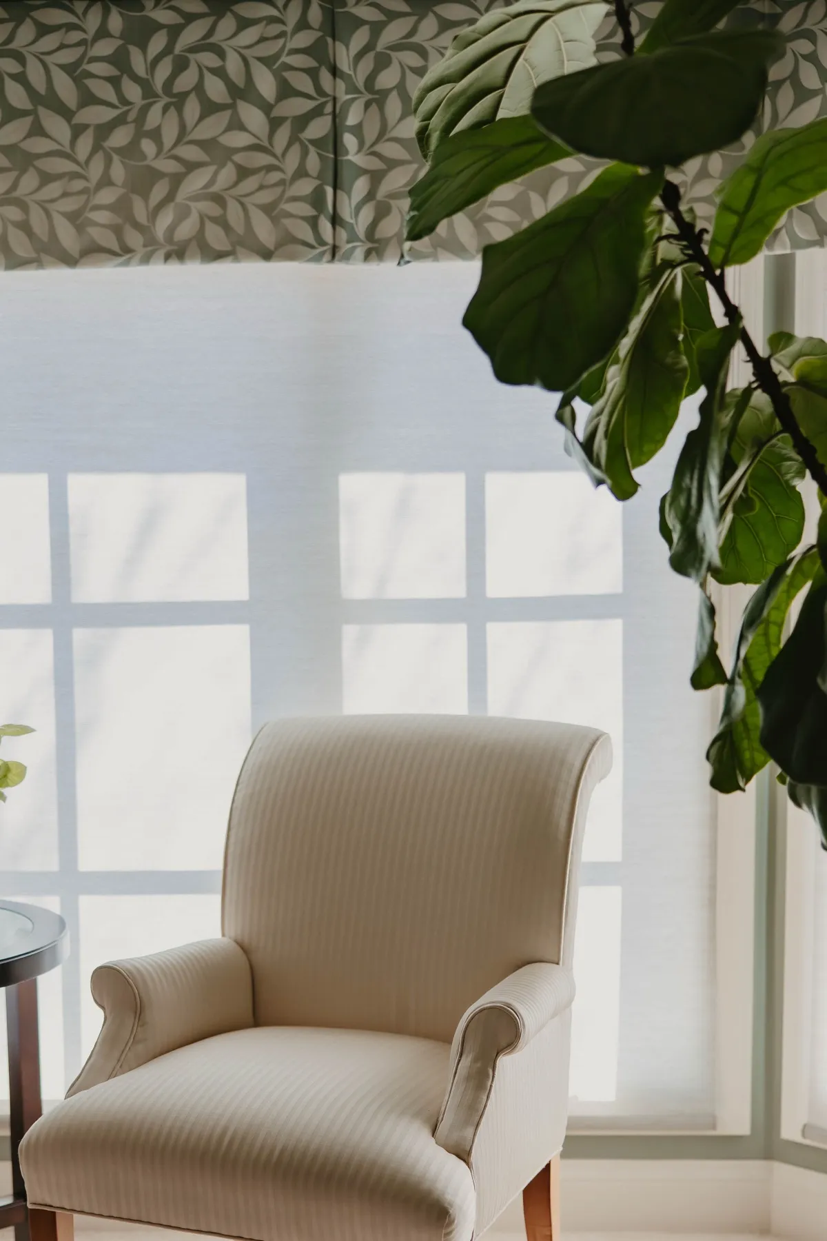 Sunroom window with a screen shade under a patterned valance