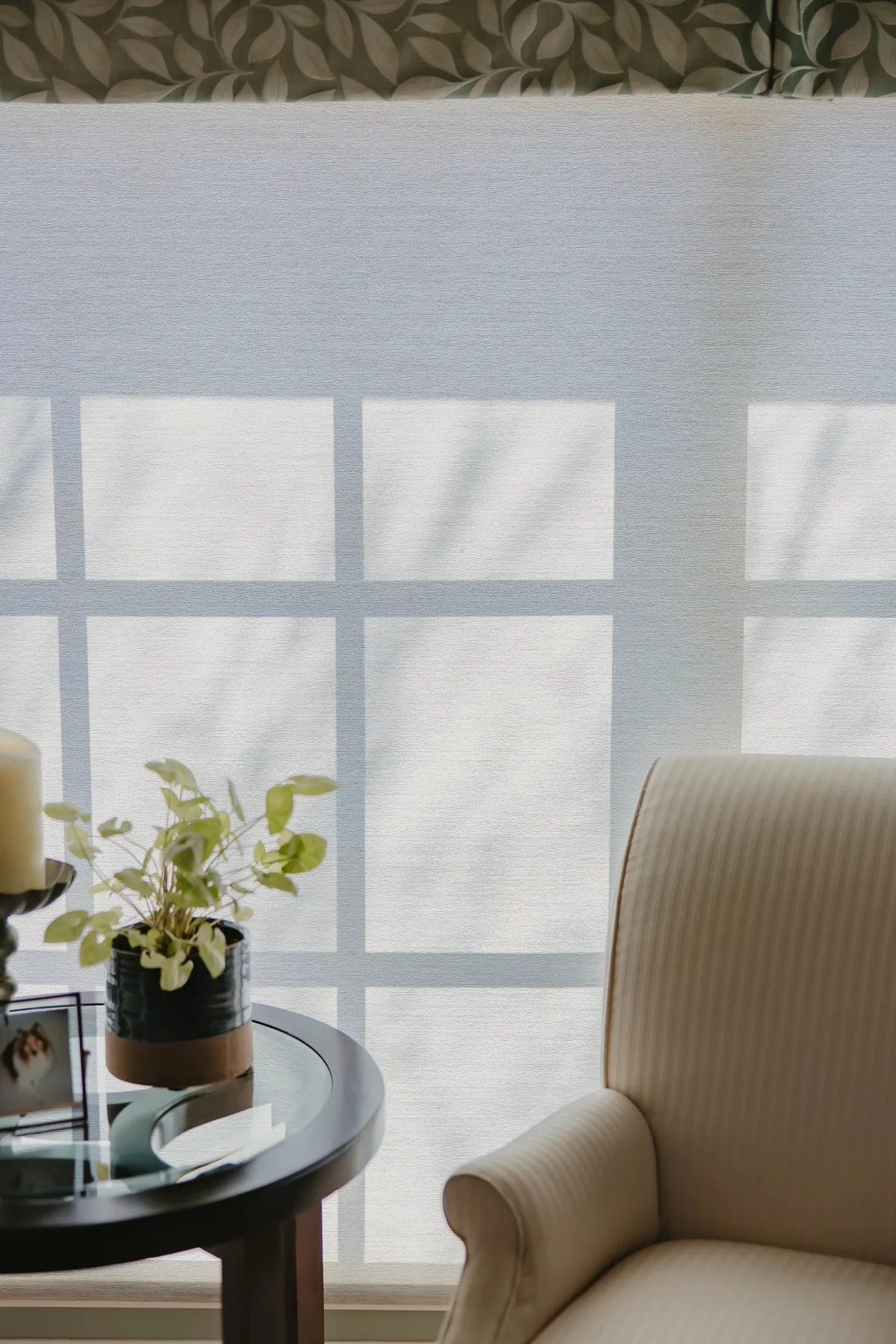 Morning light through a screen shade beside an armchair