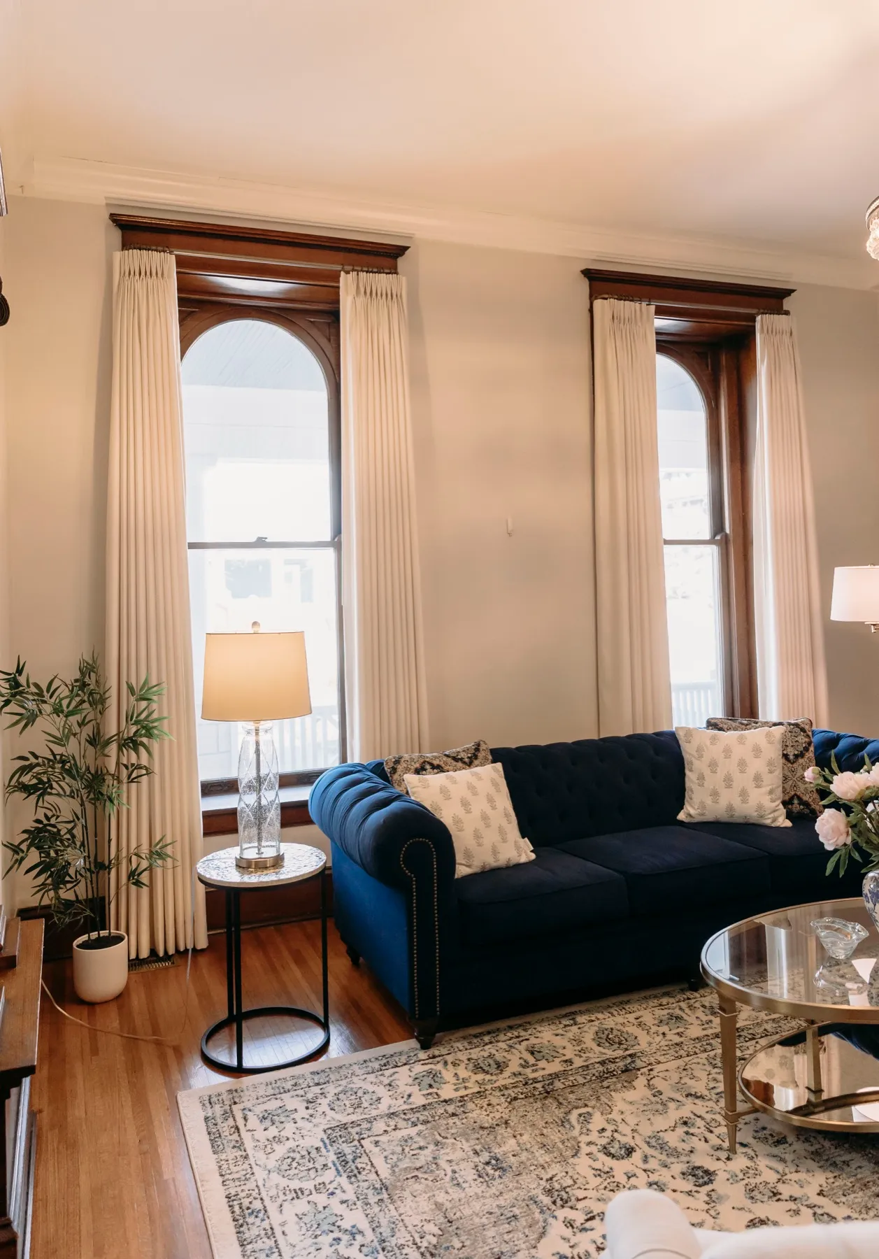 Formal living room with pinch-pleat draperies on tall arched windows