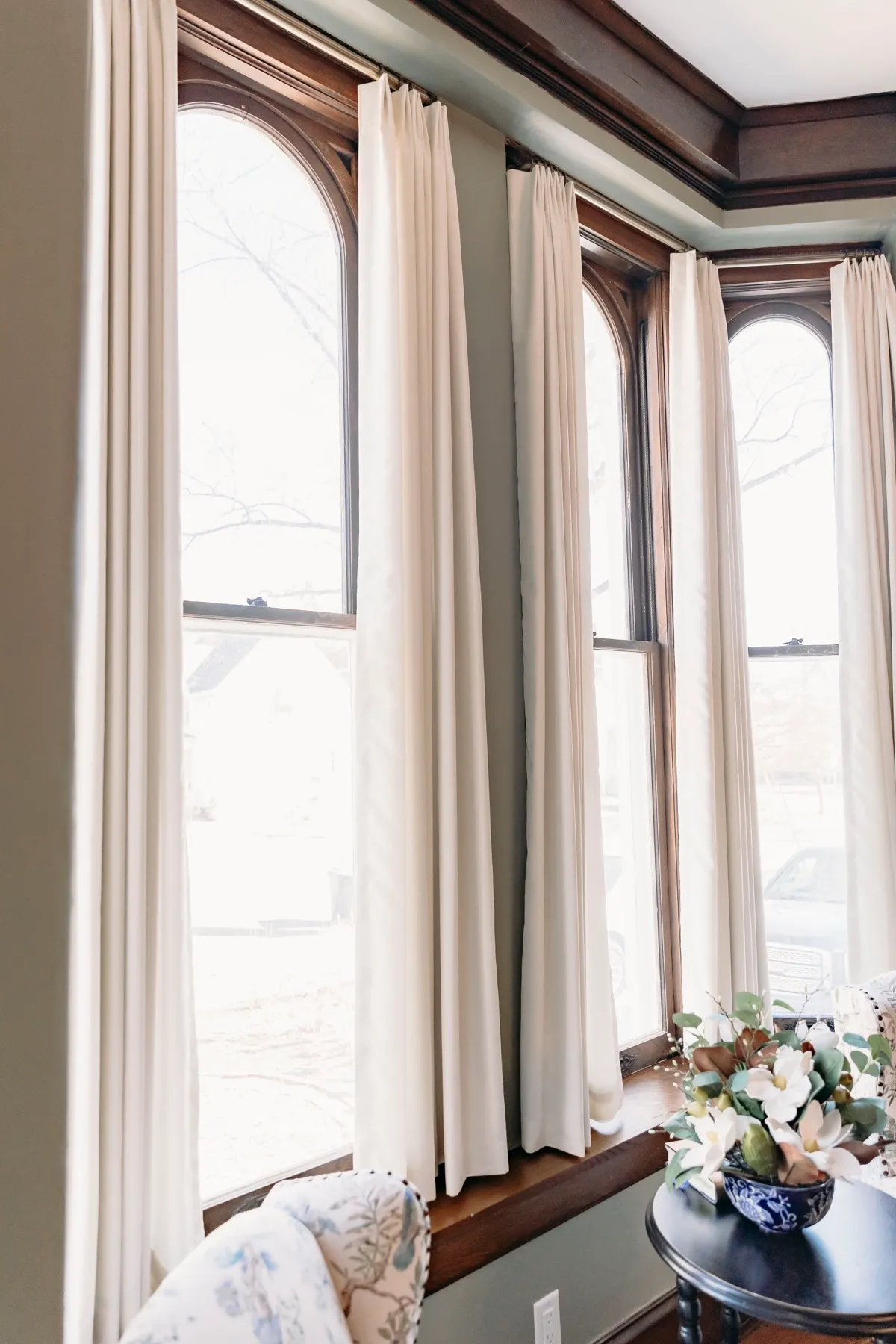 Draperies hanging below original carved woodwork