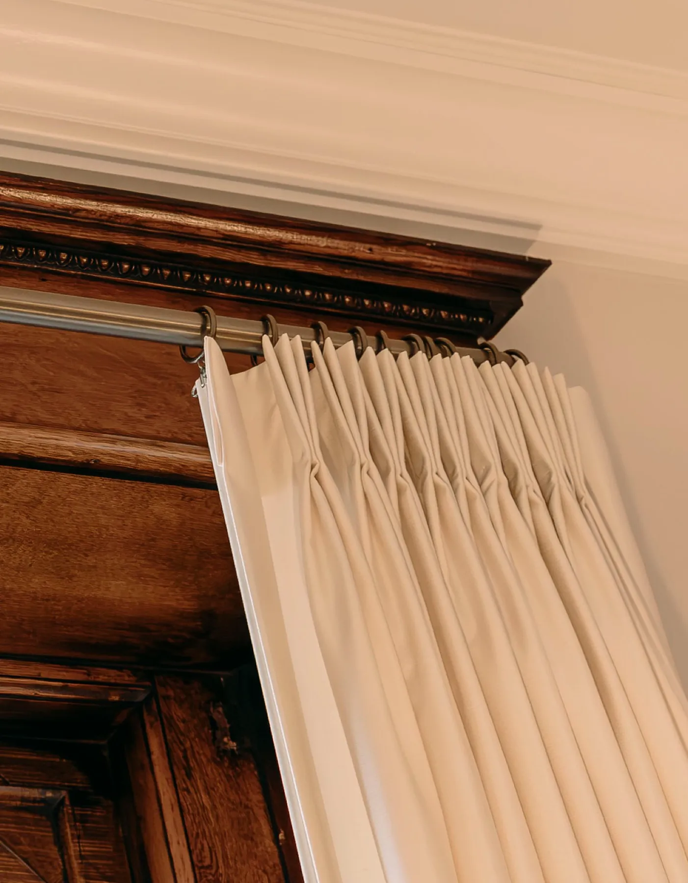 Close-up of a pinch-pleat heading below a wood cornice