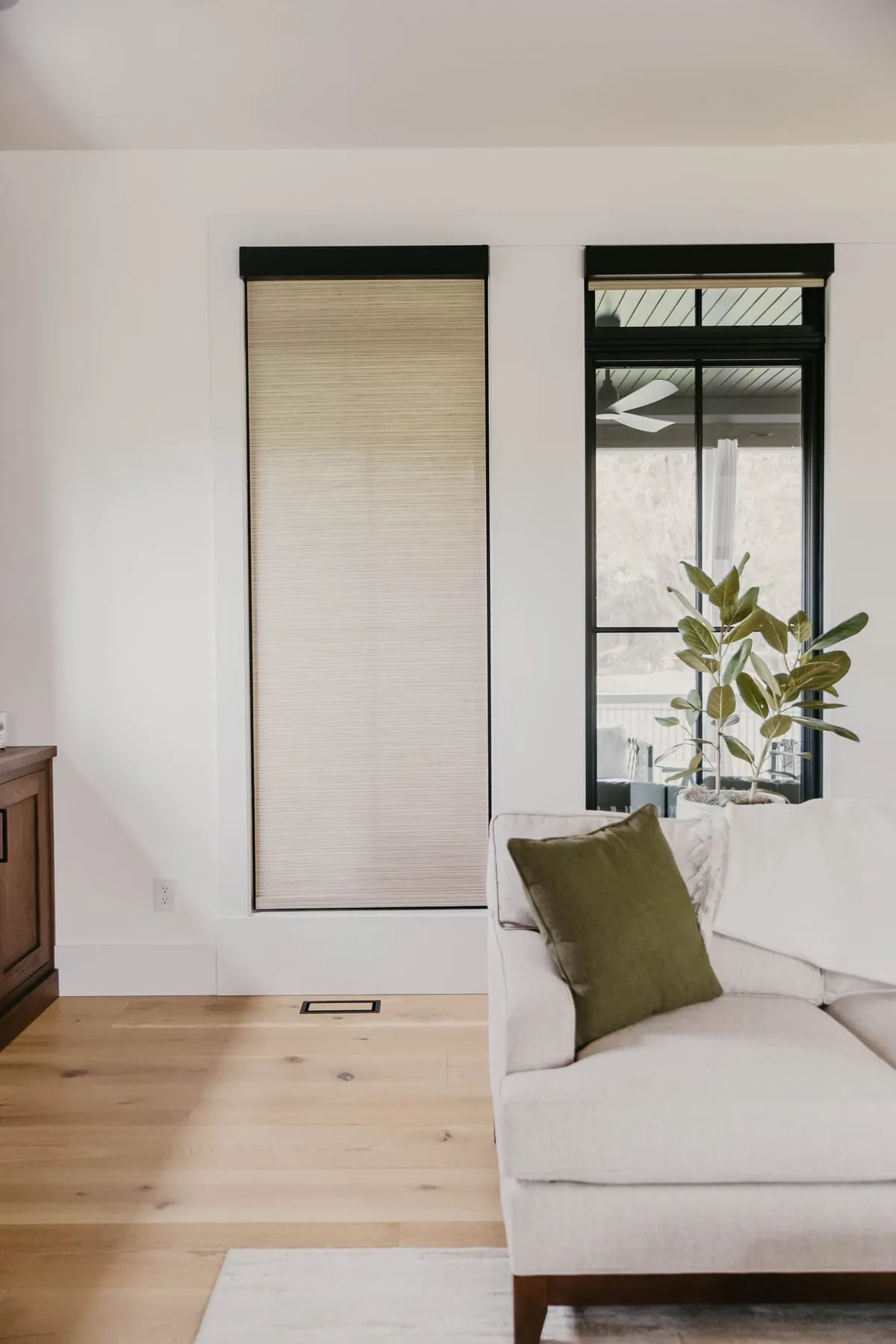 Bright living room with woven shades on tall windows