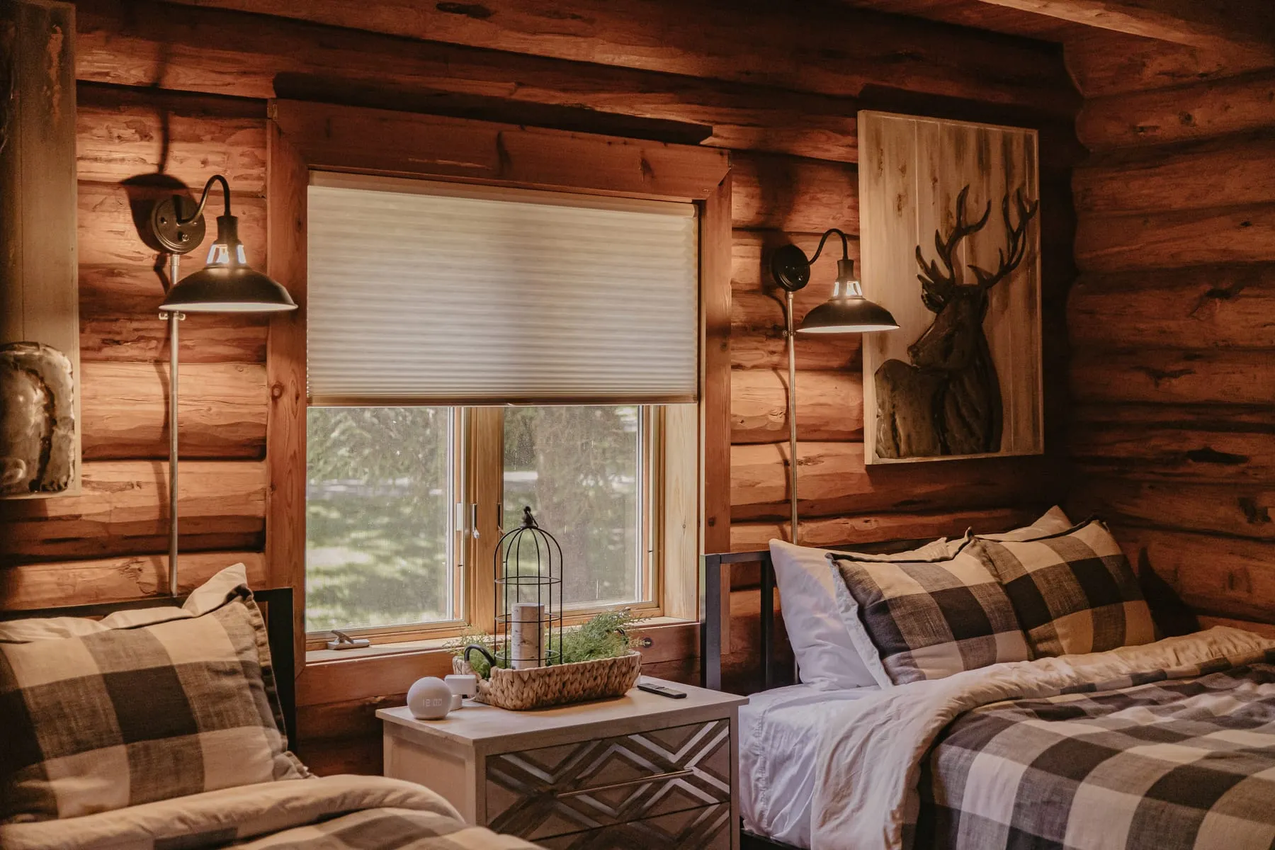 Log cabin bedroom with a light-filtering shade between two lamps