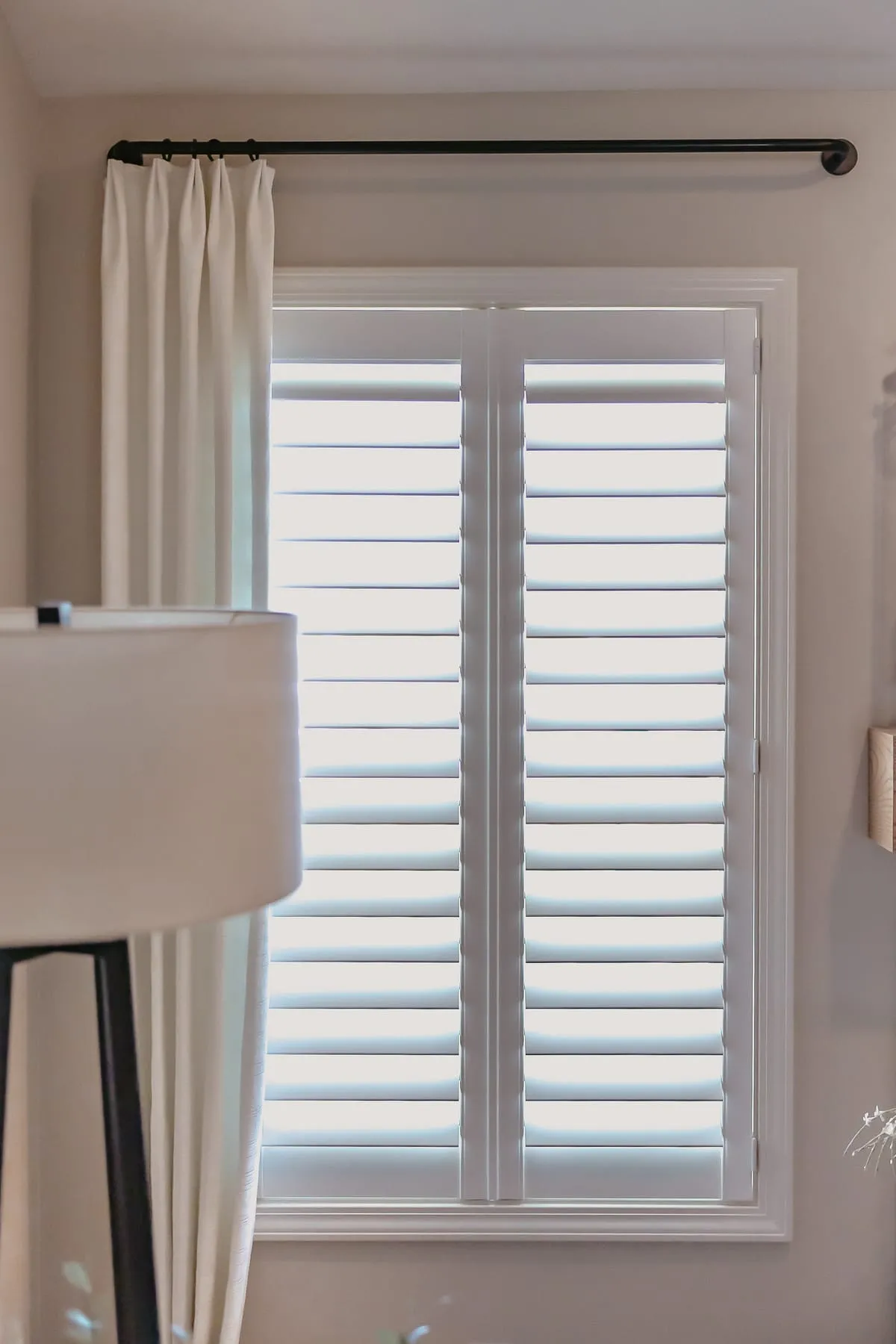 White shutters with a drapery panel