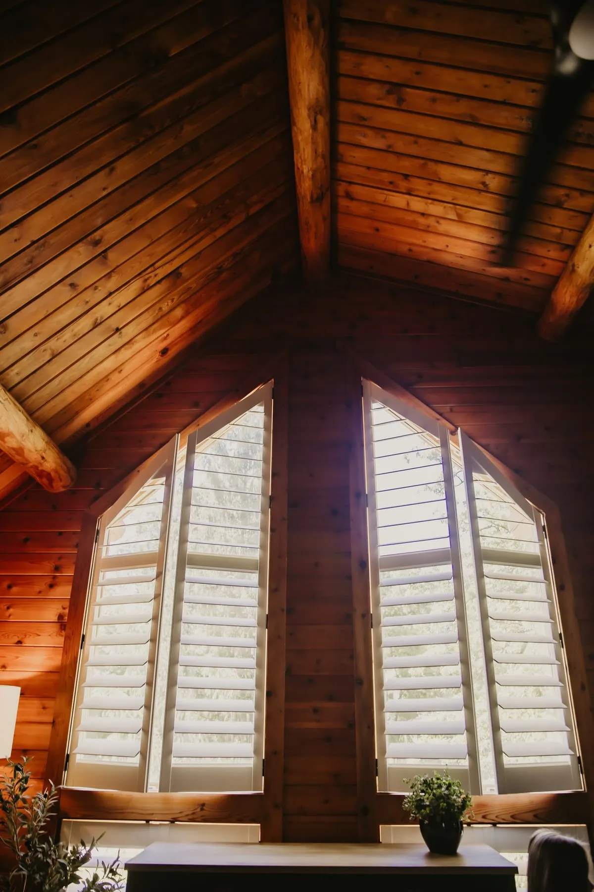 Arched shutters under a wood ceiling
