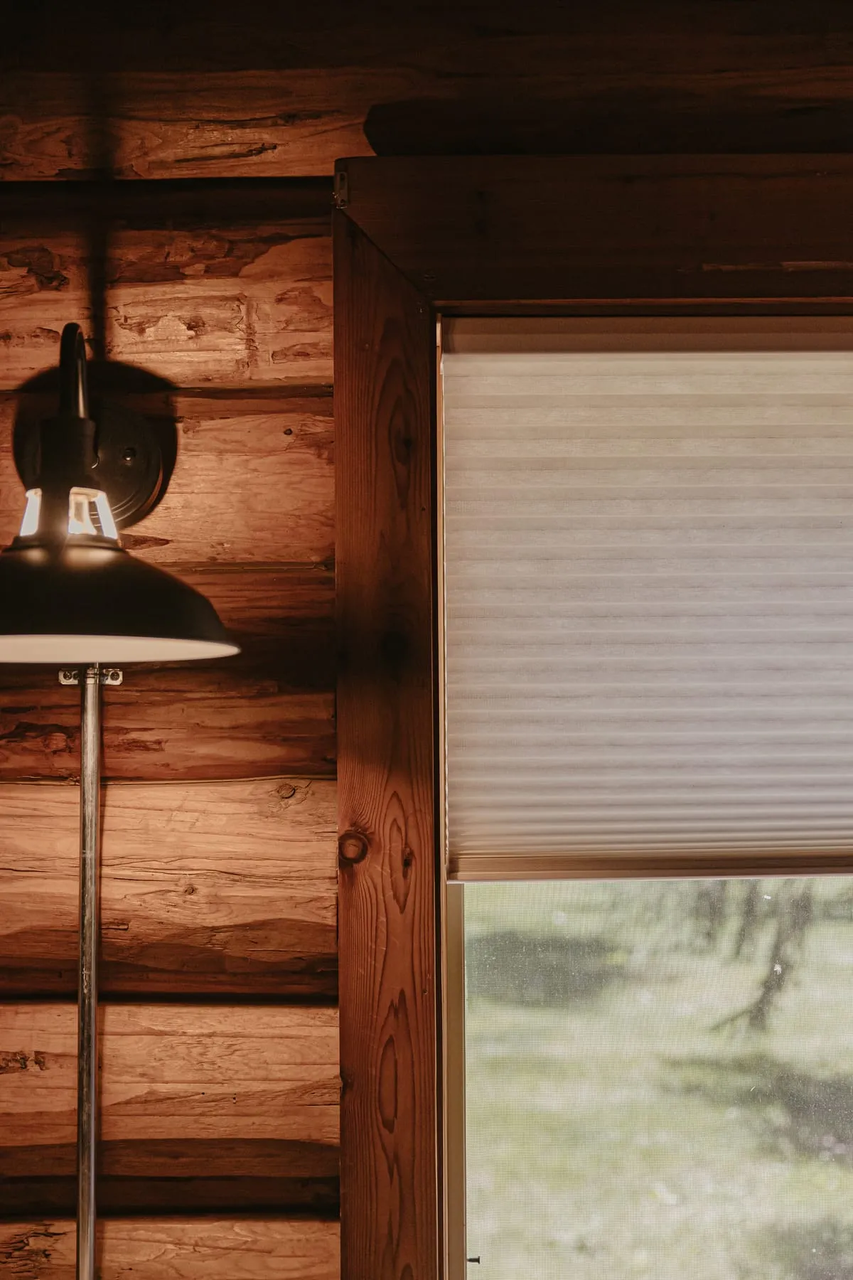 Shade lowered on a log cabin window