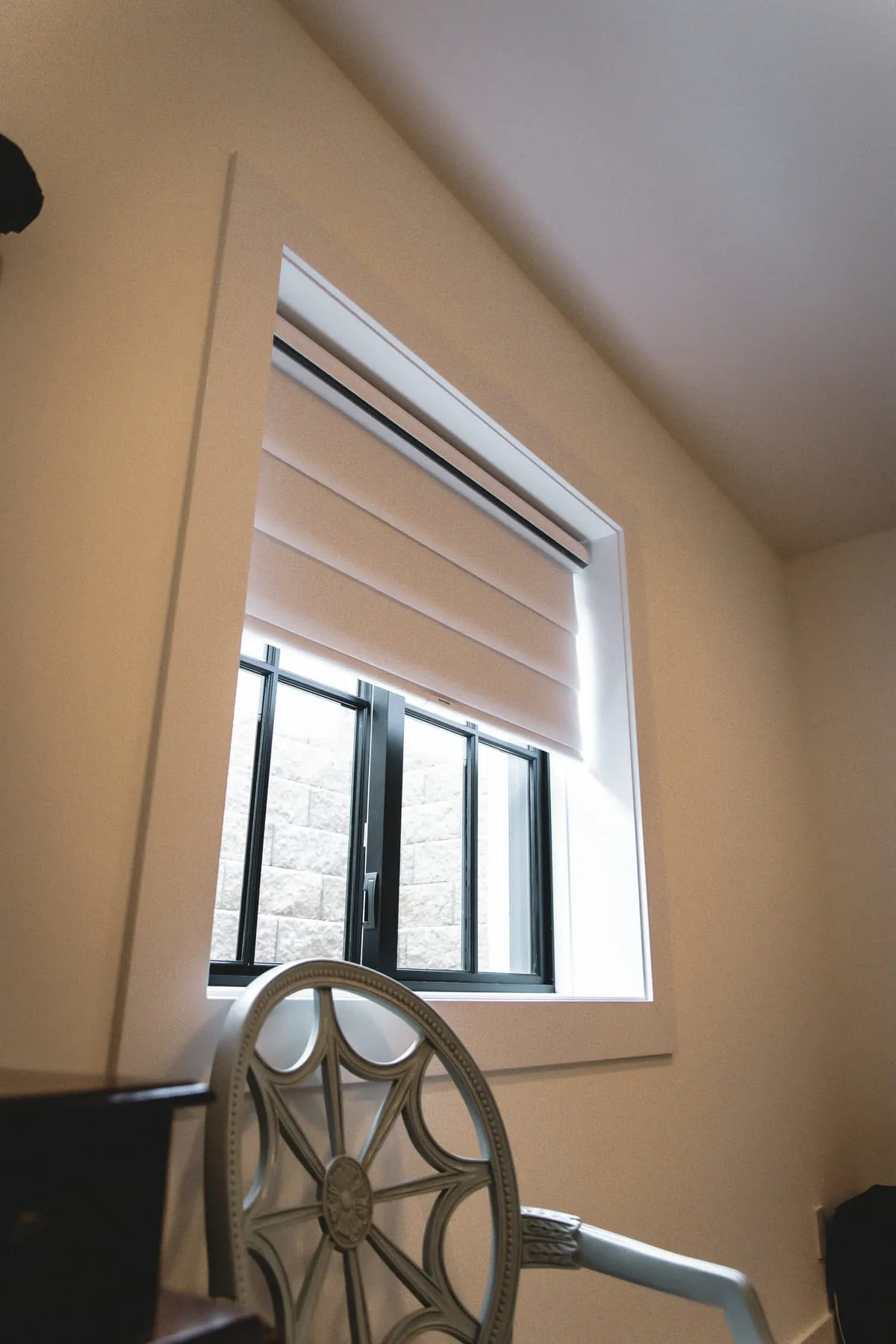 Fabric shade raised on a black-framed window