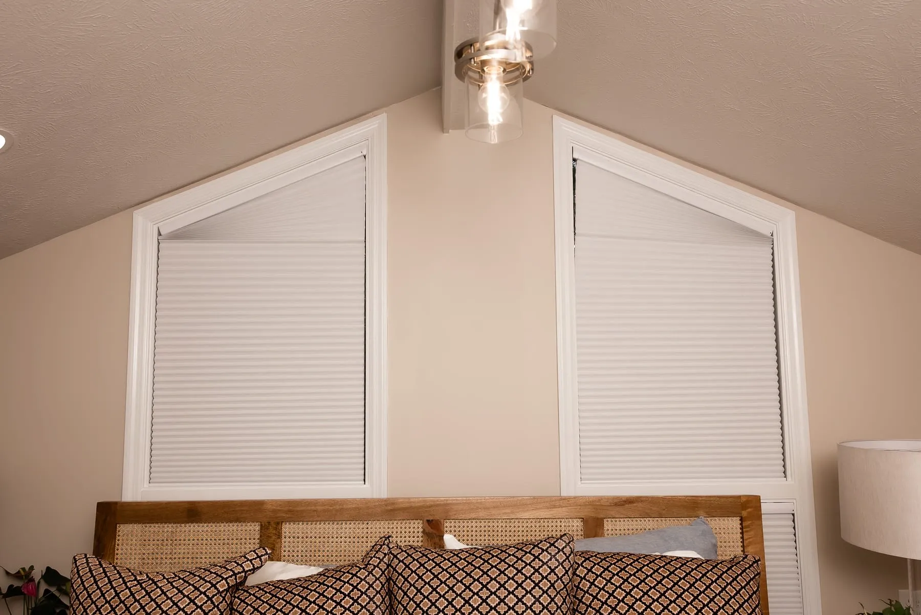 Angled window above a bed fitted with a shade
