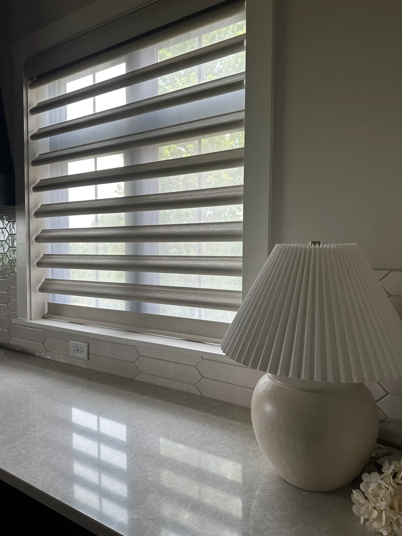 Pirouette® shade lowered behind a counter lamp
