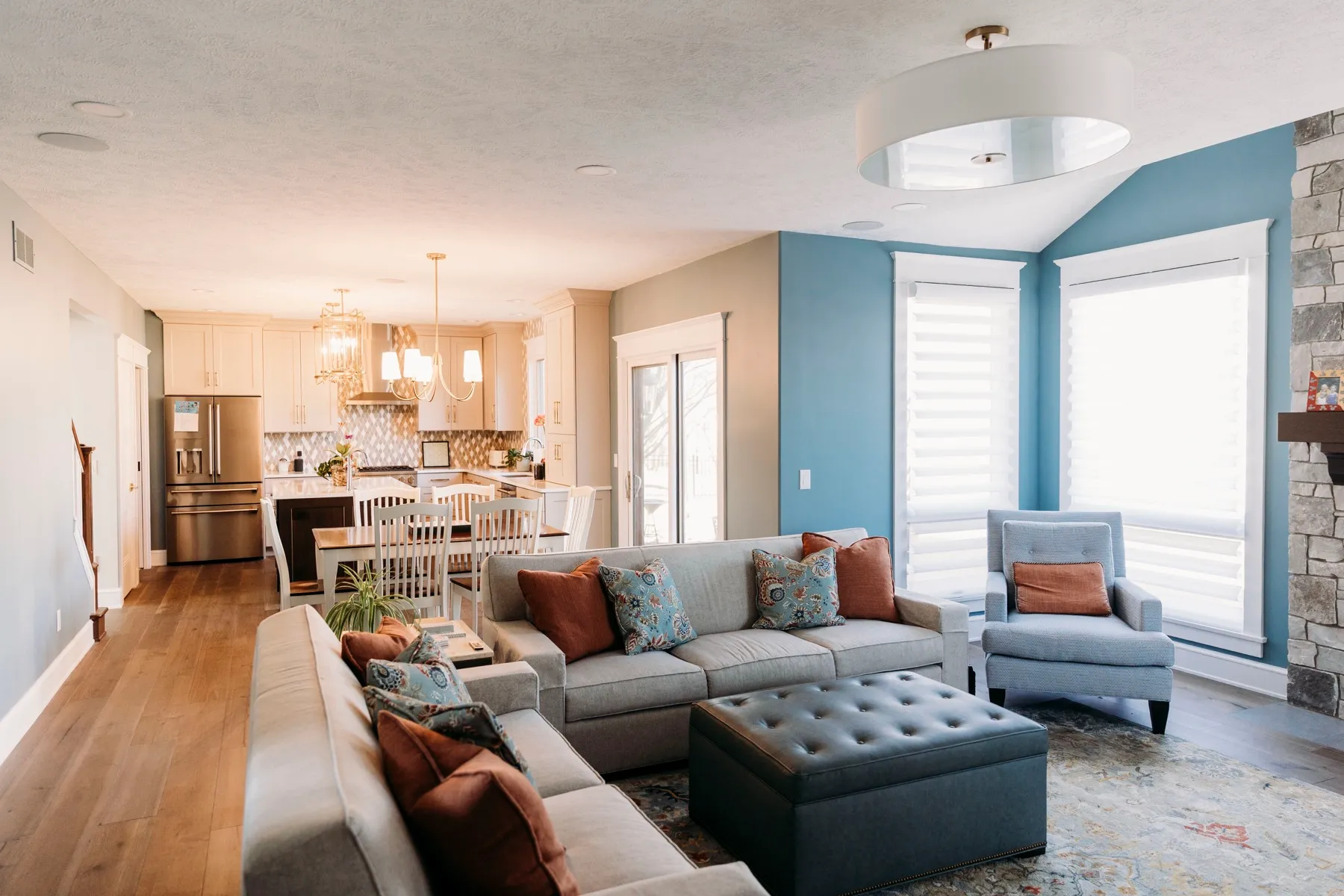 Open living and kitchen area with shades on every window