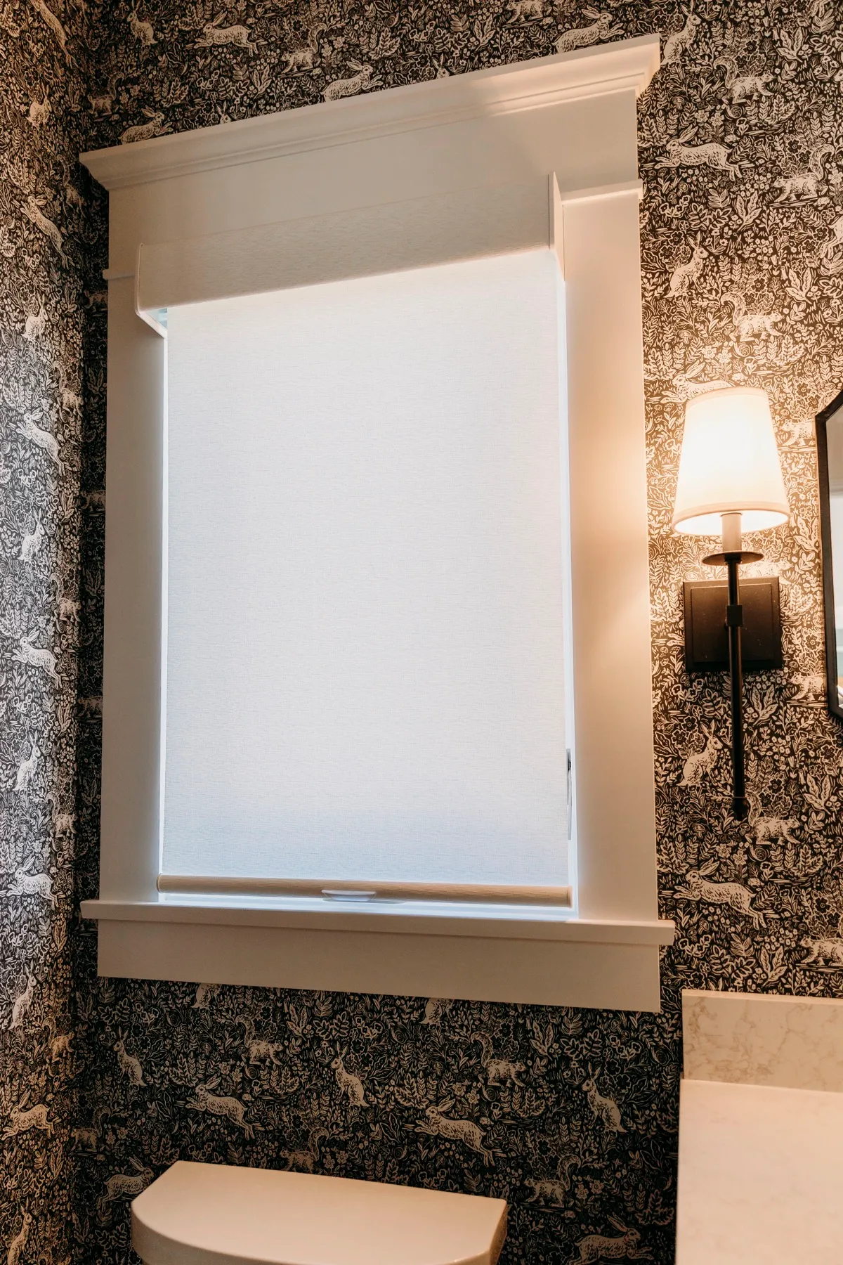 Powder room window with a white roller shade