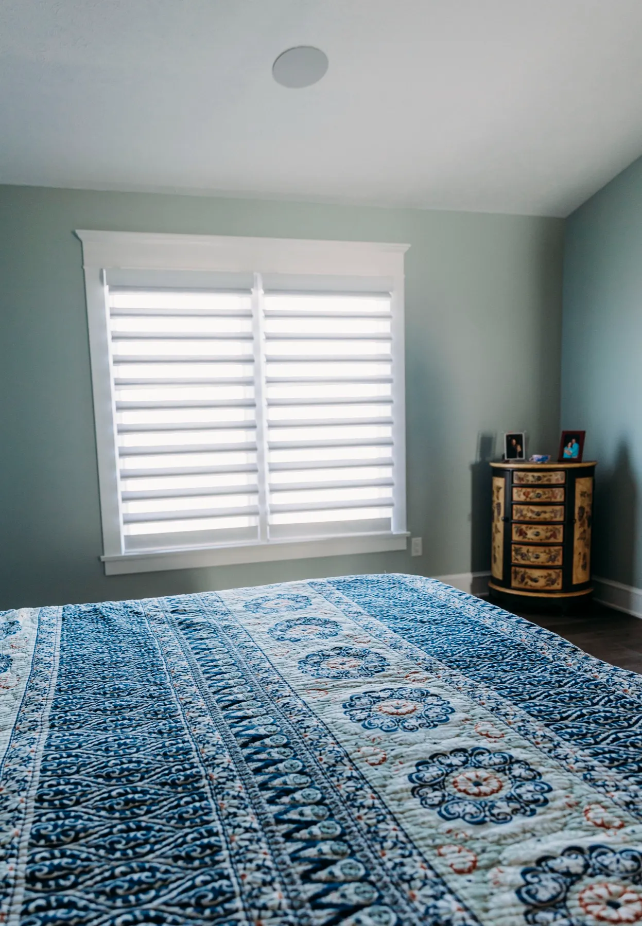Bedroom window with a sheer shading above a blue rug