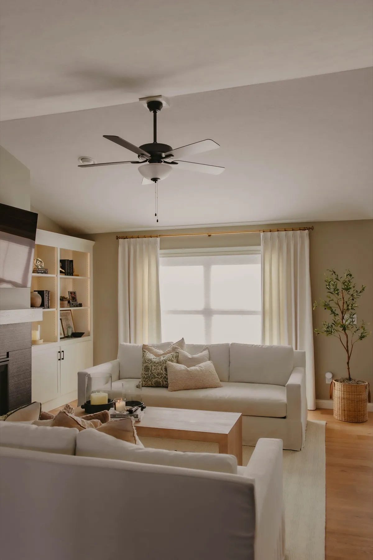 Open living room with ivory drapery panels over light-filtering shades