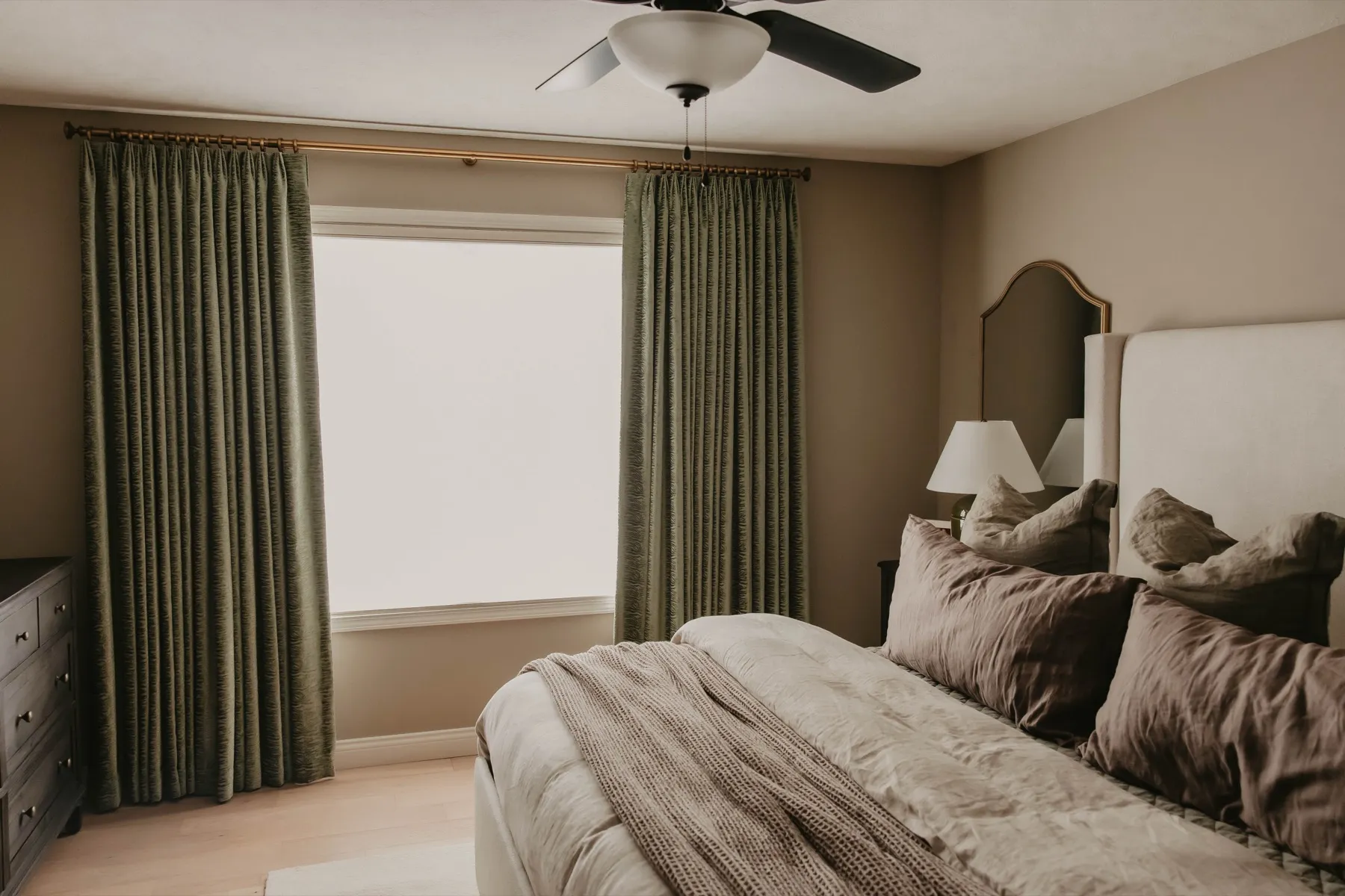 Bedroom with green patterned draperies on both windows