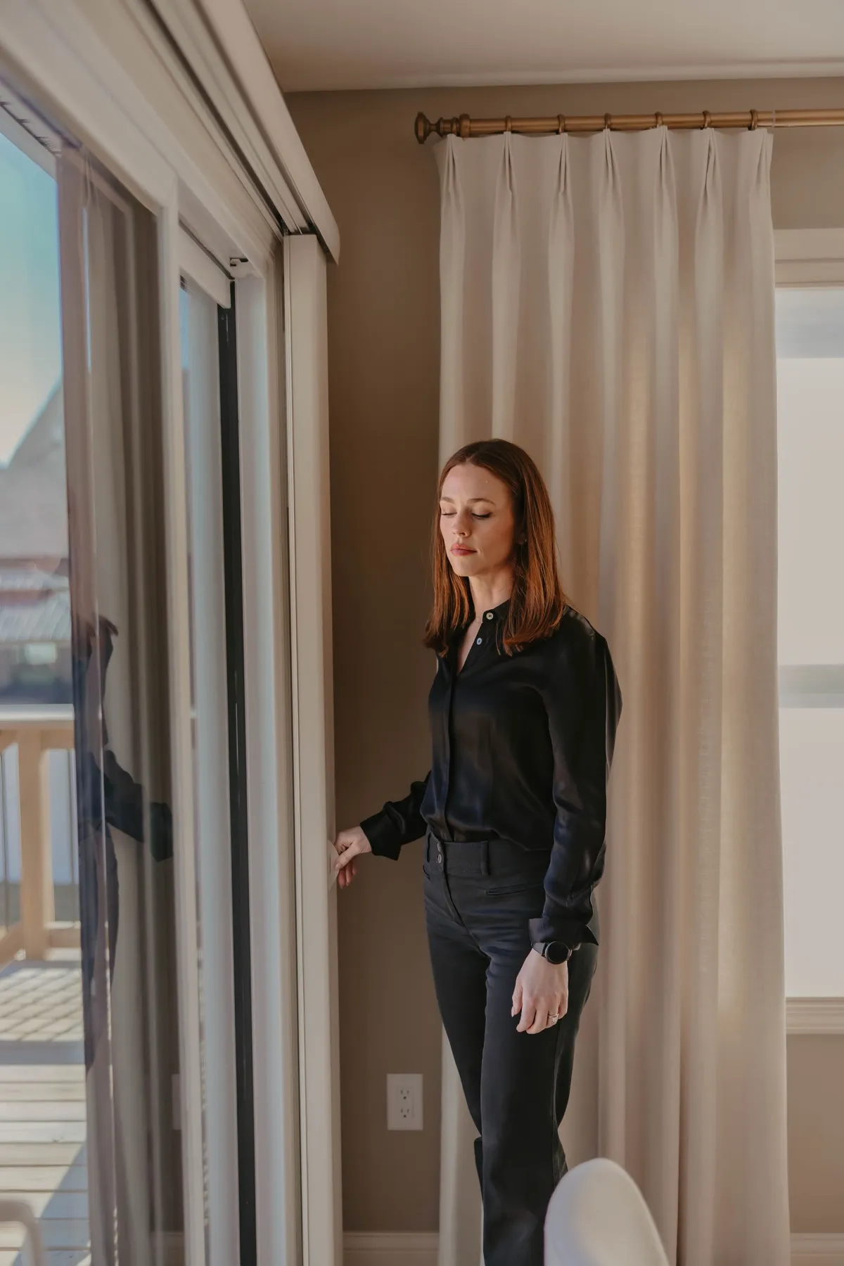 Sliding door framed by a tall drapery panel