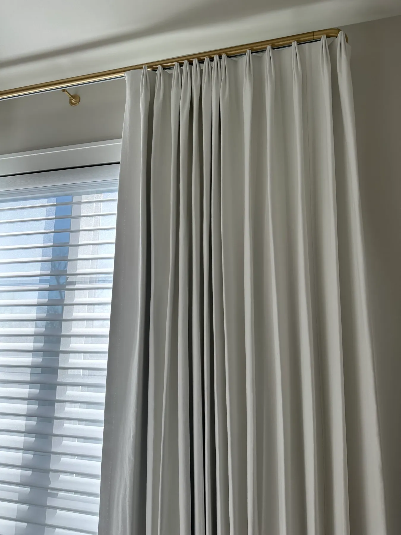 Pleated drapery panel hung from a slim rod