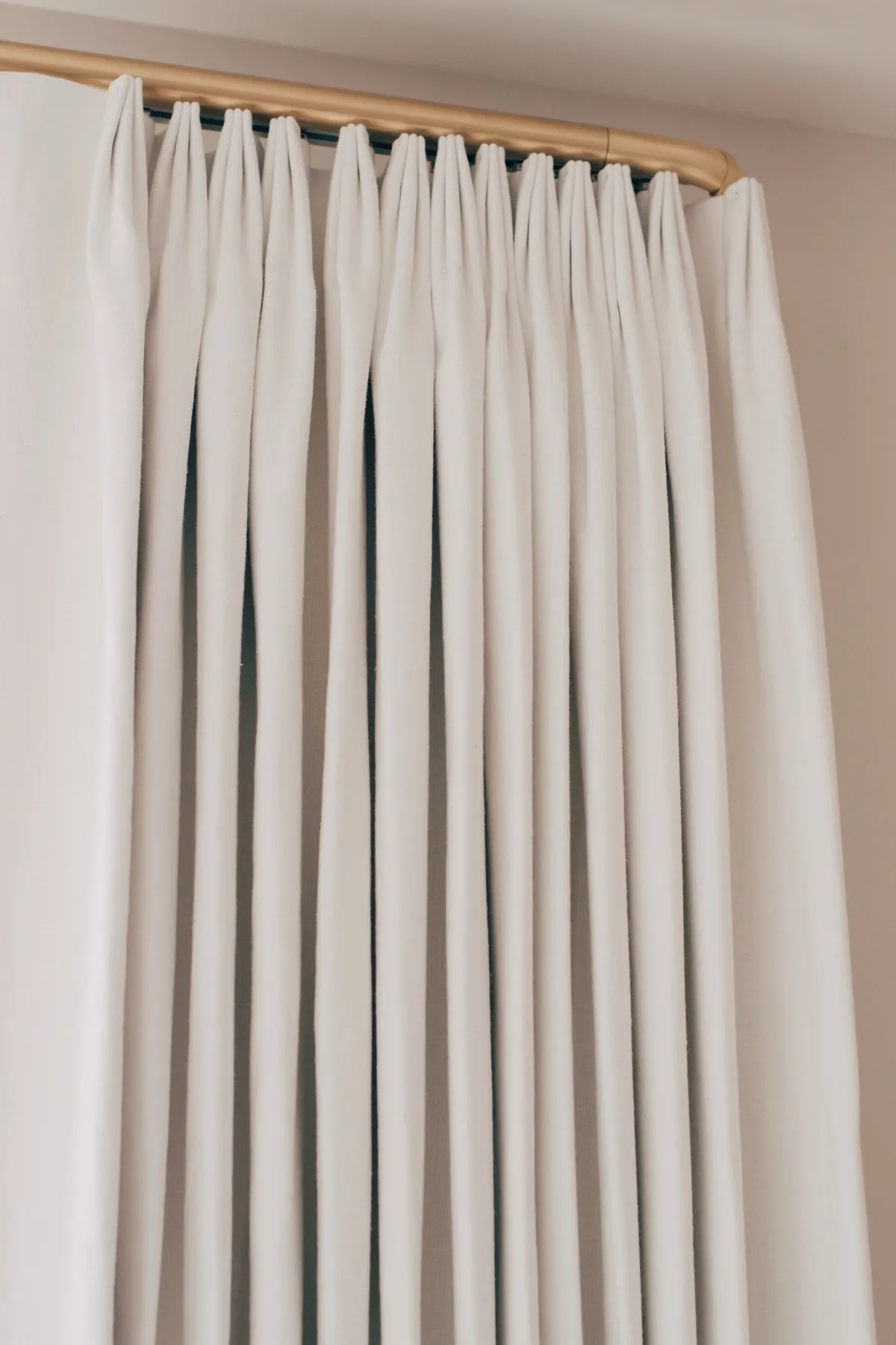 Pleated drapery heading on a brass rod