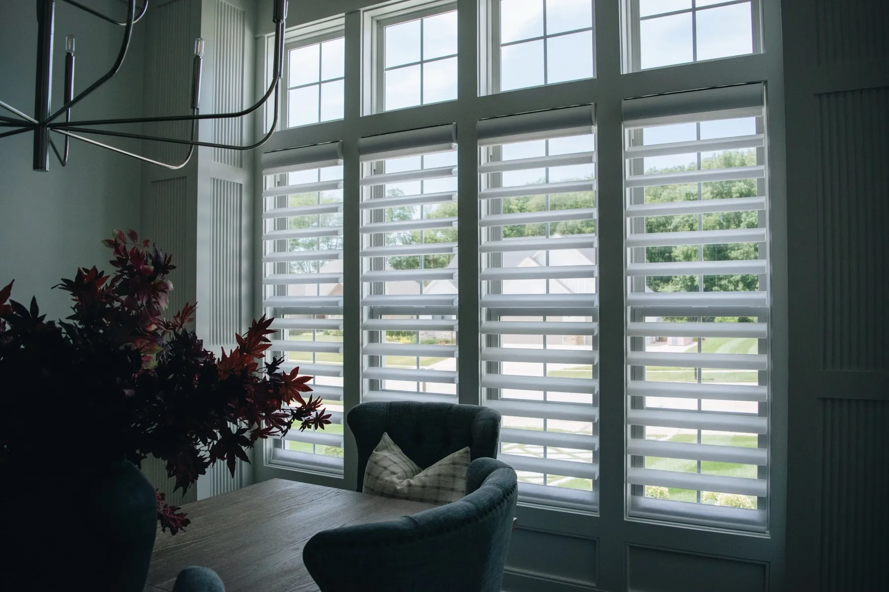 Sunroom with white Pirouette® shades on a wall of windows