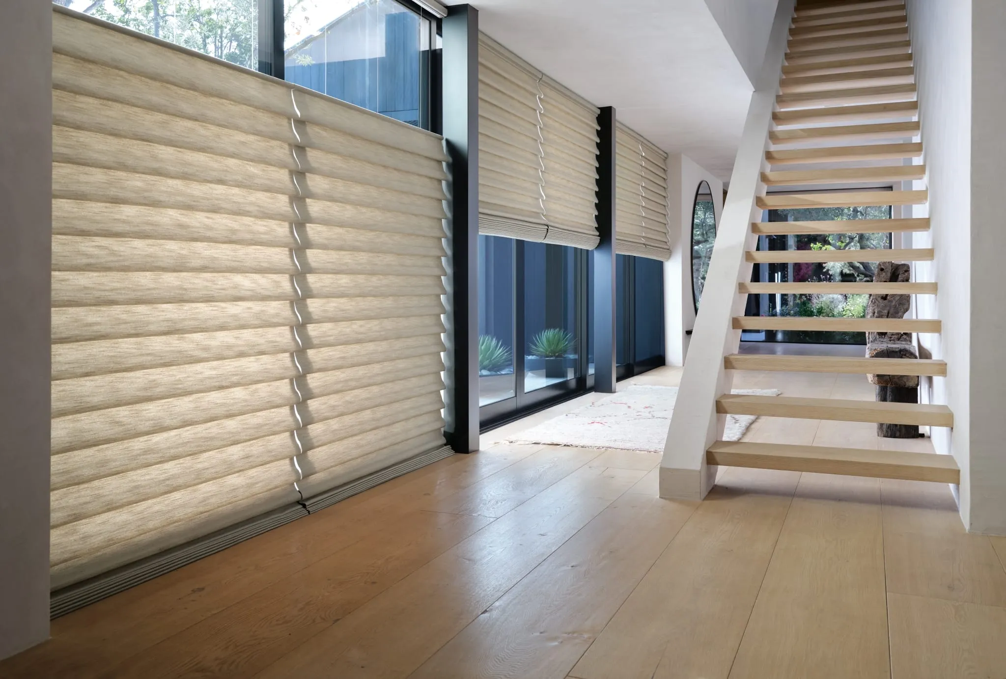 Vignette® modern Roman shades on tall windows in an open stairway hall